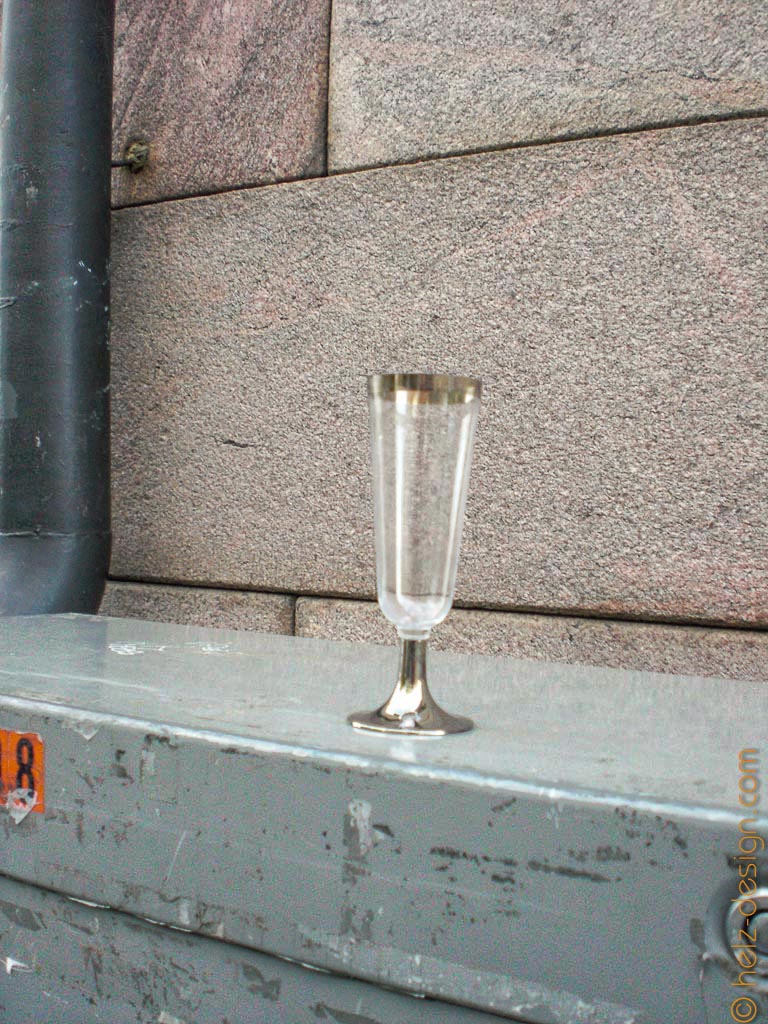 Ein einsames Sektglas auf einem Stromkasten